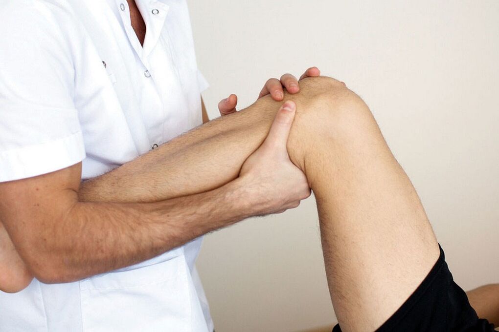 a doctor who examines a knee with osteoarthritis